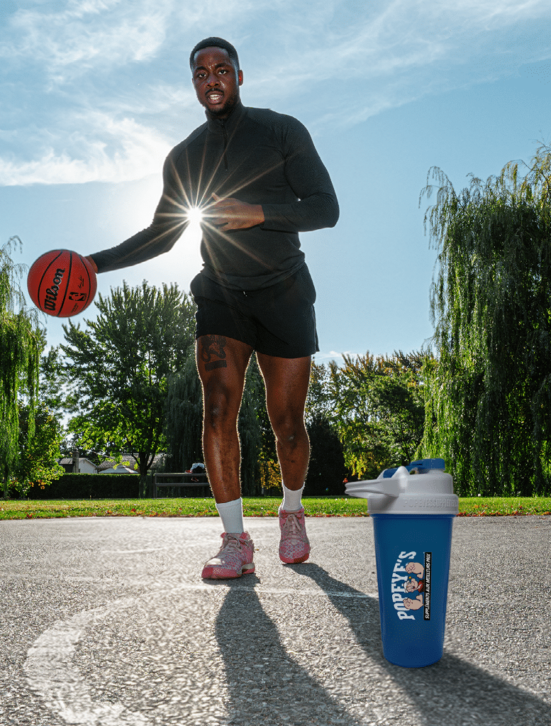 A man holding a basketball and a blue cup. Description generated by AI