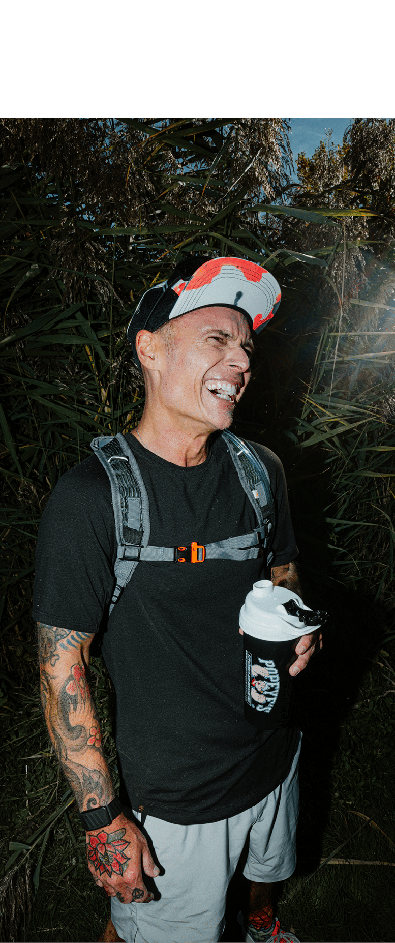A man with a backpack and a cup is smiling. AI generated content